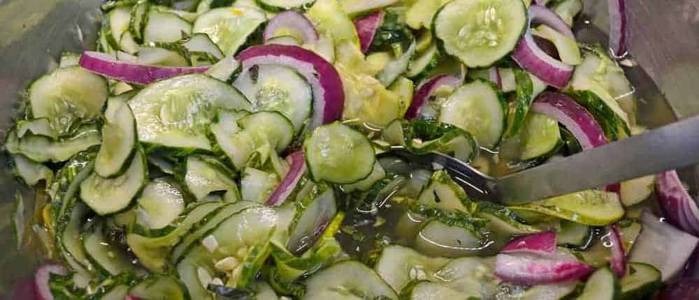 A close up of cucumbers and onions in salad