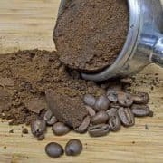 A coffee grinder and some beans on the ground