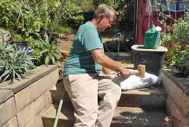 A man is washing his toilet outside