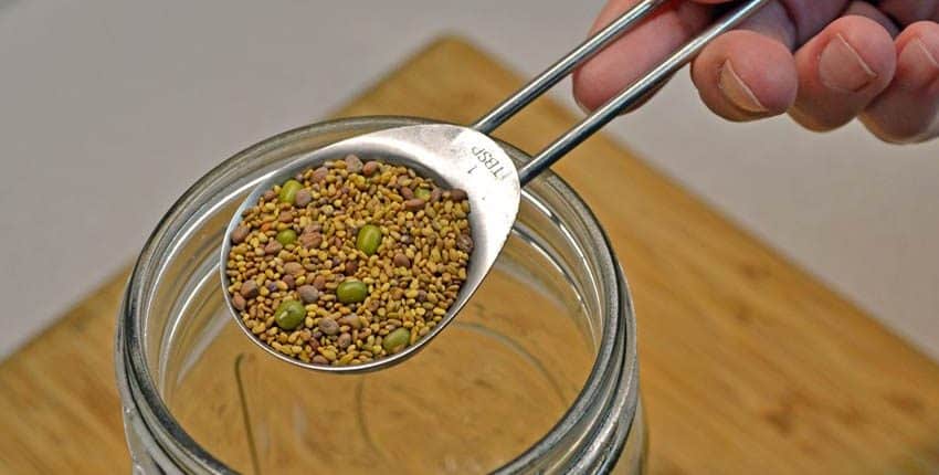 A person is holding a spoon over some food.