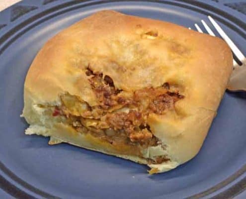 A piece of bread with meat on it.