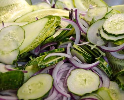 A close up of some cucumbers and onions