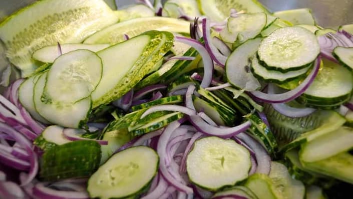 Lime-Mint Freezer Pickles Ready for Salt A close up of some cucumbers and onions
