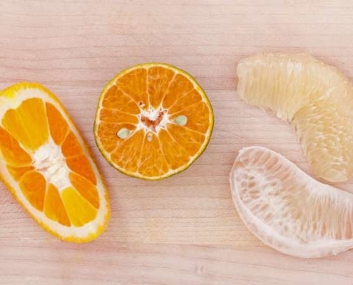 A close up of an orange and some other fruit