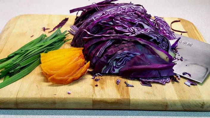 Chipotle-Cilantro-Coleslaw A cutting board with some purple cabbage and an orange.